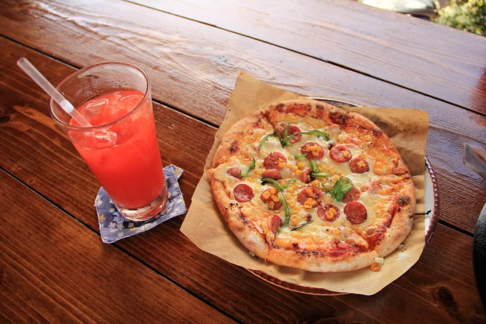 Pizza and juice on wood deck