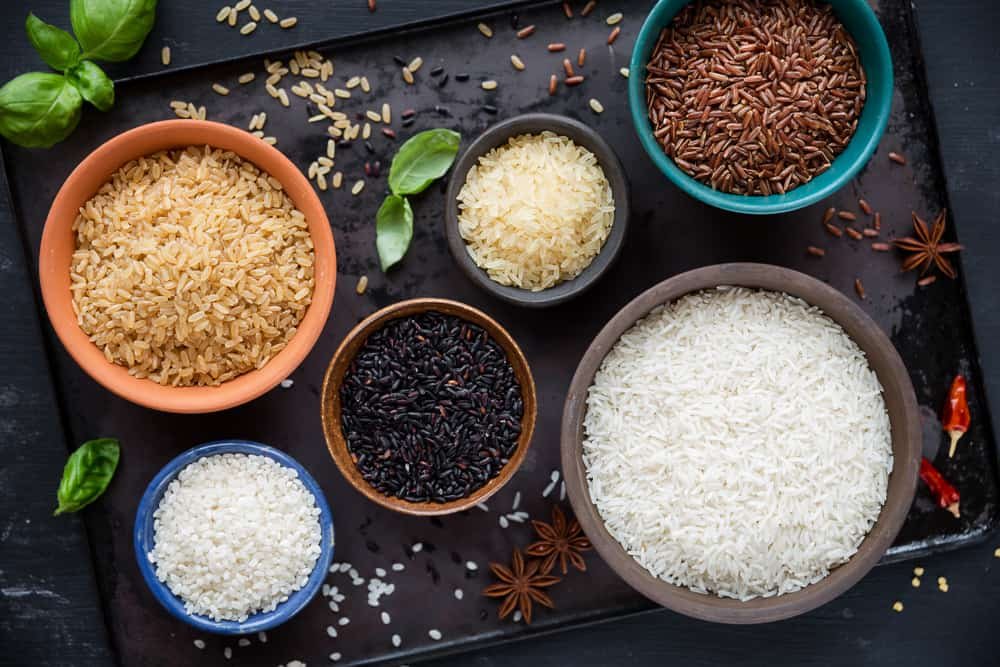 Variety of types and colours of rice - red, black, basmati, whole grain, long grain parboiled and arborio - in bowls