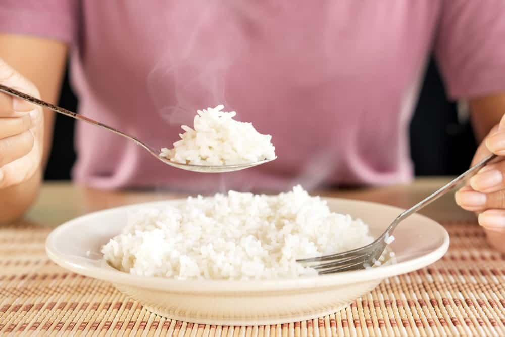 Asian woman eating cooked hot rice
